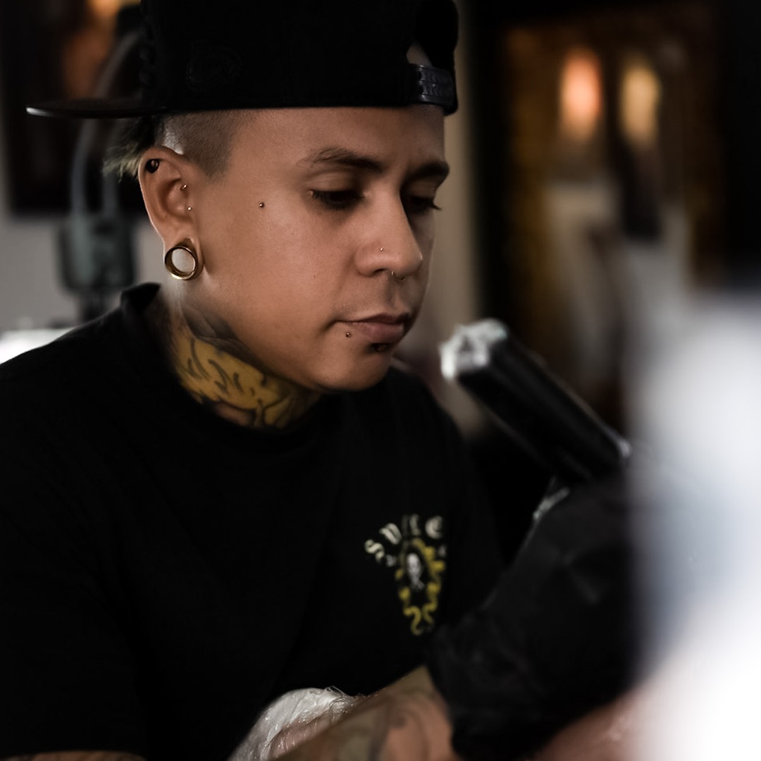 tattoo shop artists tattooing a customer