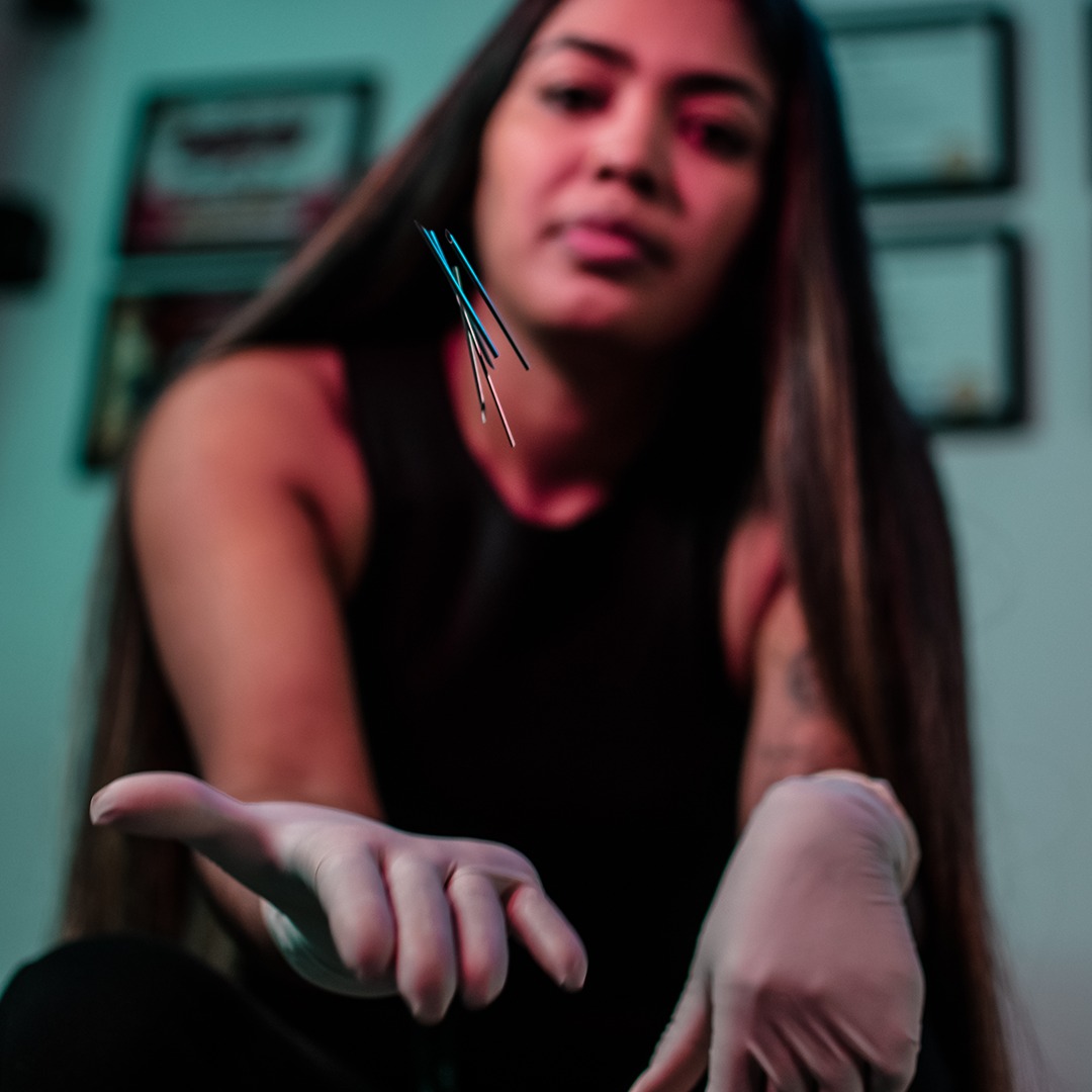 tattoo shop girl holding piercing needles