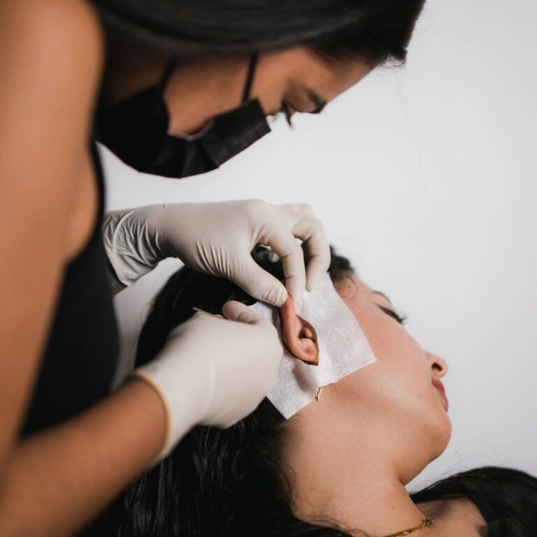 tattoo shop girl piercing a customer's ear